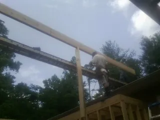 Carpenter setting a ridge beam over a new addition frame — Ice Dam Removal by Roofing Brothers in Burkburnett