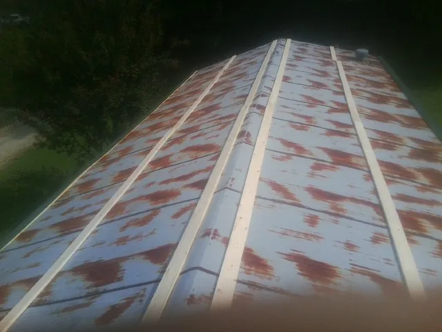 Rusted metal roof panels with new wood purlins before replacement — Storm Damage Roof Repair in Burkburnett by Roofing Brothers