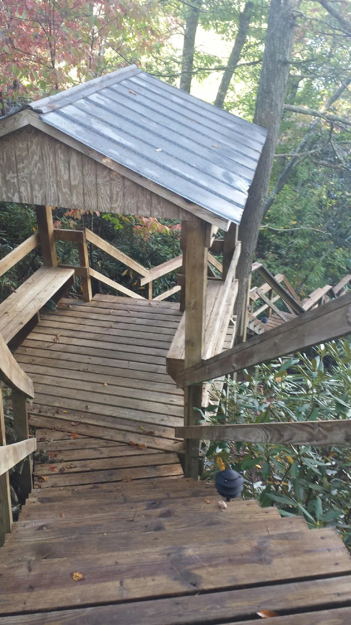 Metal roofed shelter over wooden steps on a wooded walkway — Skylight Repair & Installation work by our crew in Burkburnett