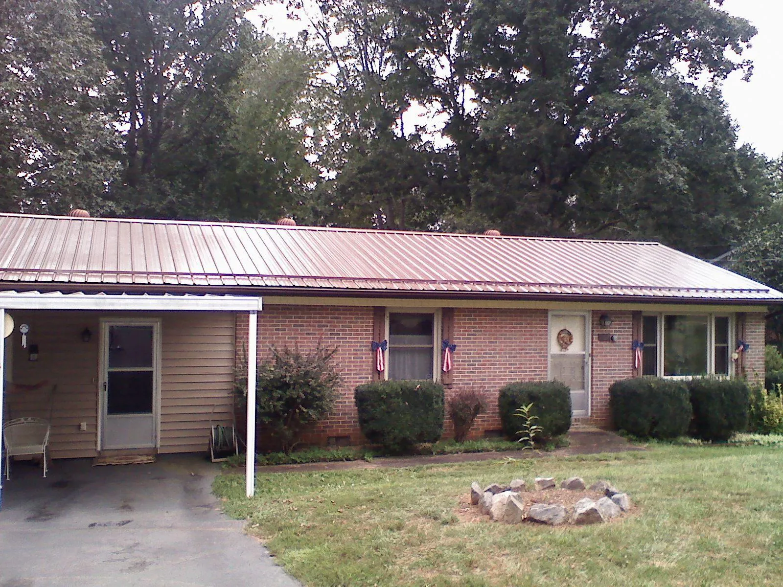 Bronze metal roof and carport on a brick ranch home — Roof Repair work by our crew in Burkburnett