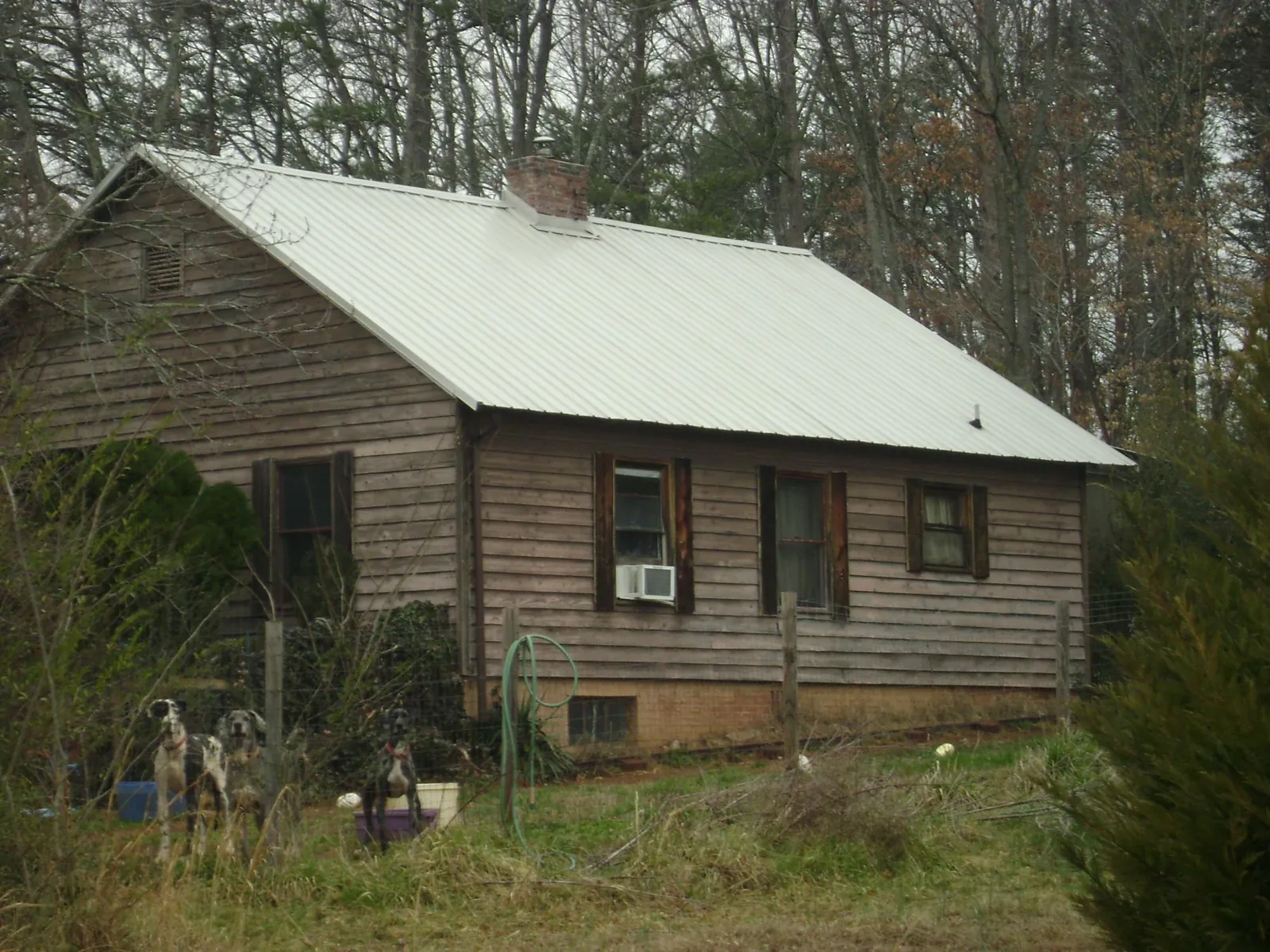 White metal roof on an old wood sided farmhouse, from a Metal Roof Installation job in Burkburnett